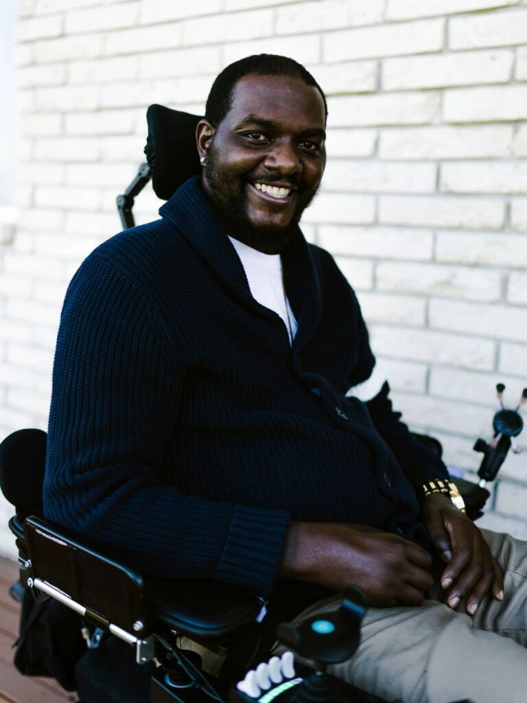 A black man in a power wheelchair